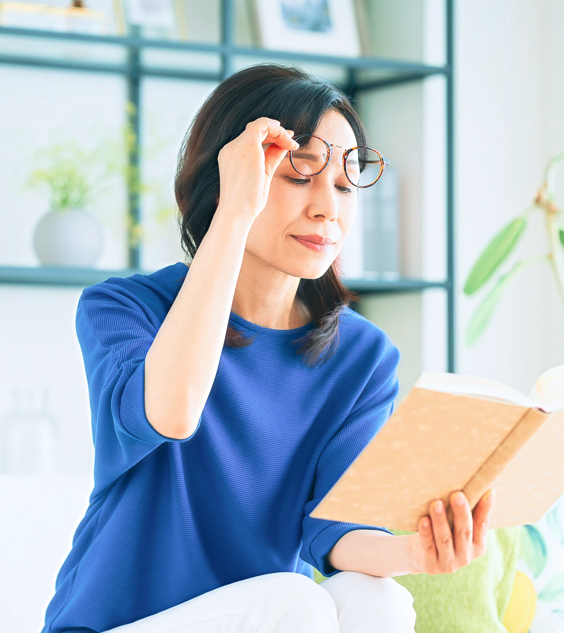 老眼鏡を持ち上げて手元を見る女性
