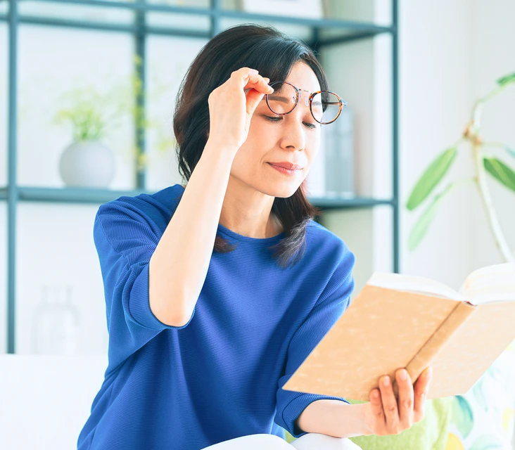 老眼鏡を持ち上げて手元を見る女性
