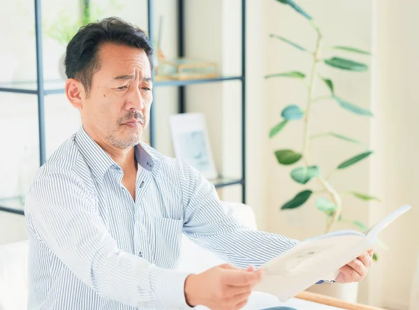 書類の文字が見えにくい男性