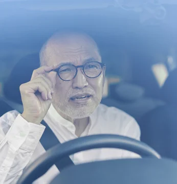 運転中に眼鏡をずらして見る男性